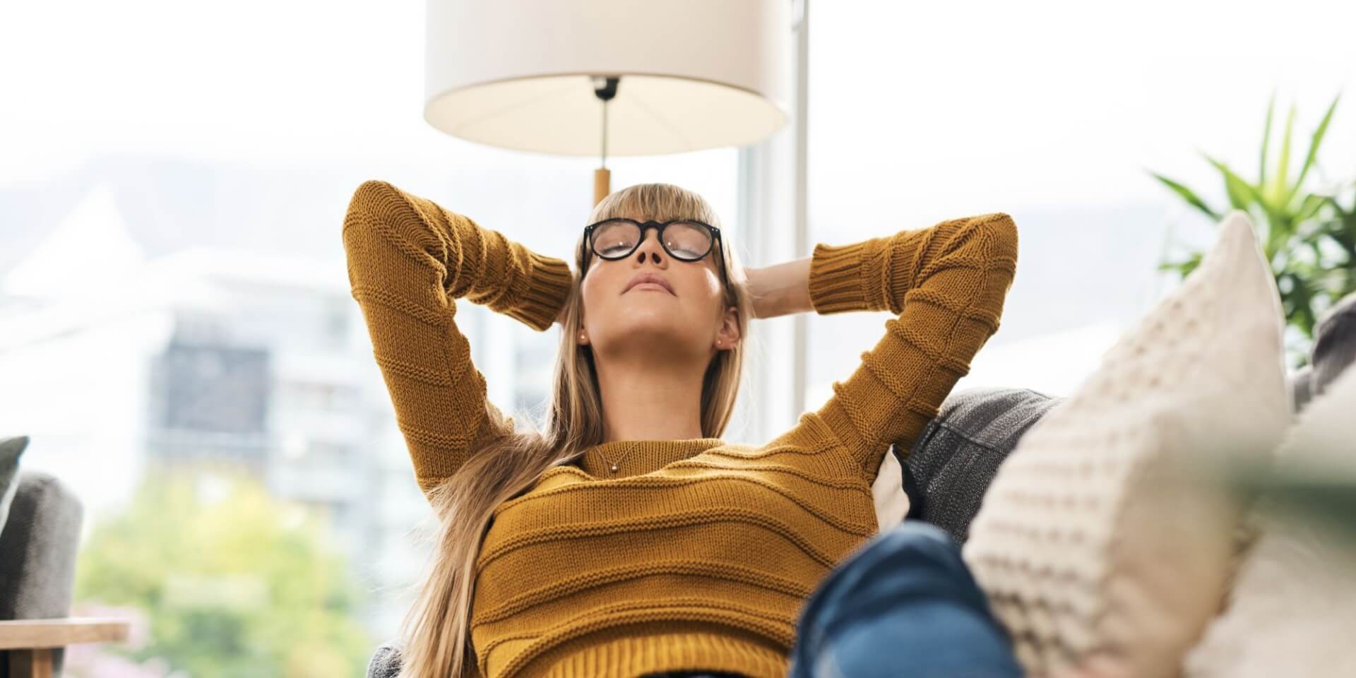 A woman lounging on a couch, practicing self-compassion.