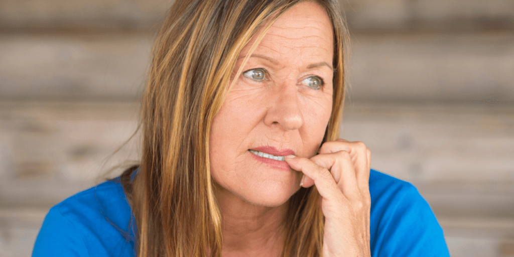 A woman engaged in body-focused repetitive behavior by biting her nails.