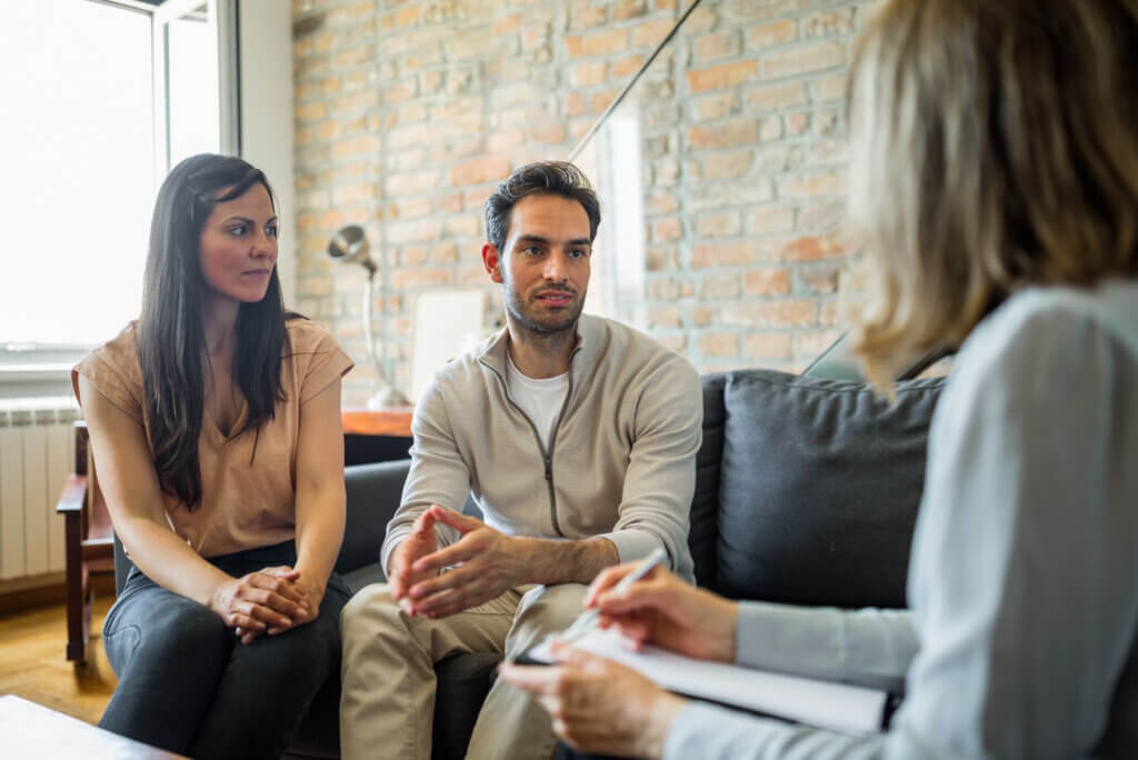 A couple in therapy, seated on a couch.